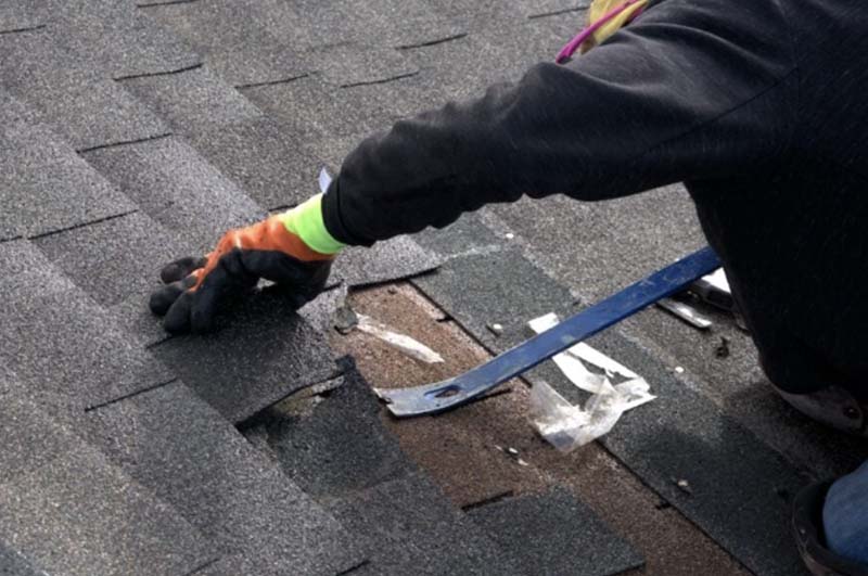 Homeowner fixing and replacing his asphalt shingle in Ann Arbor, Michigan