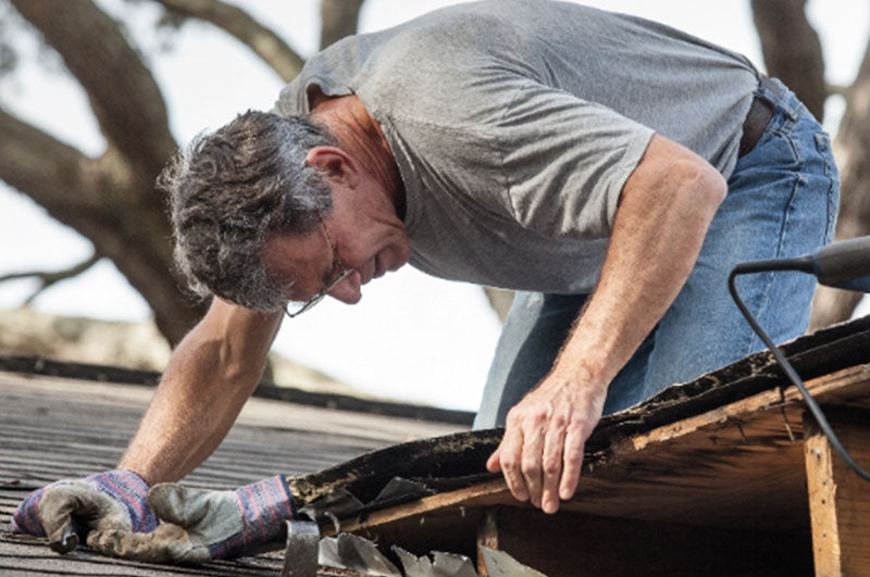 Man doing DIY roofing repairs on his Toledo, Ohio home