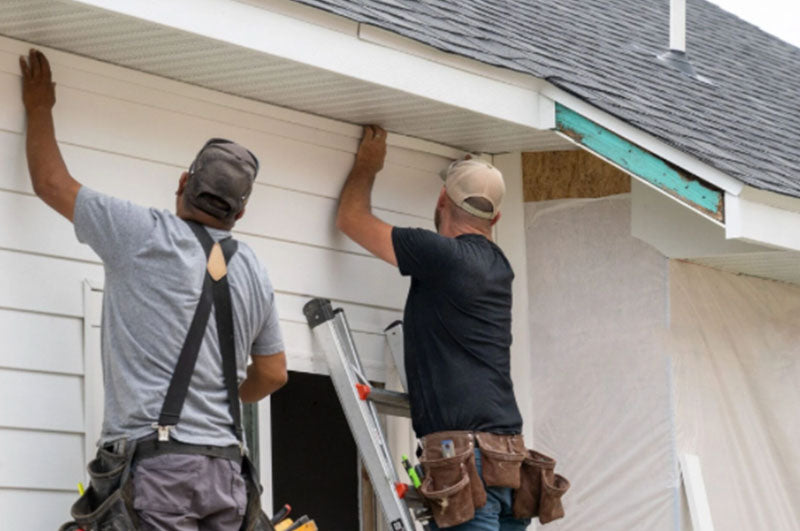 two men installing siding on a spring day