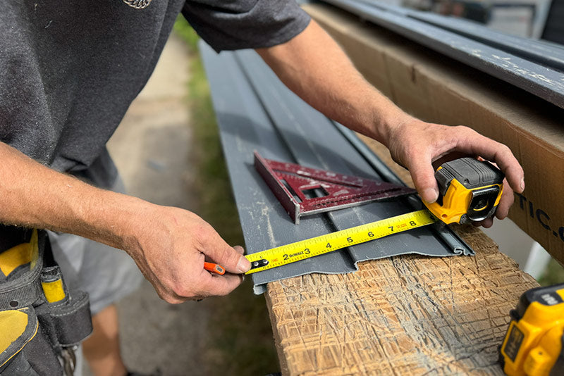 Contractor measuring siding