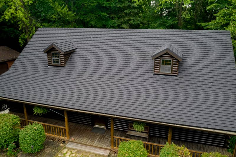 Aerial view of a cabin with a gray roof and dormer windows.
