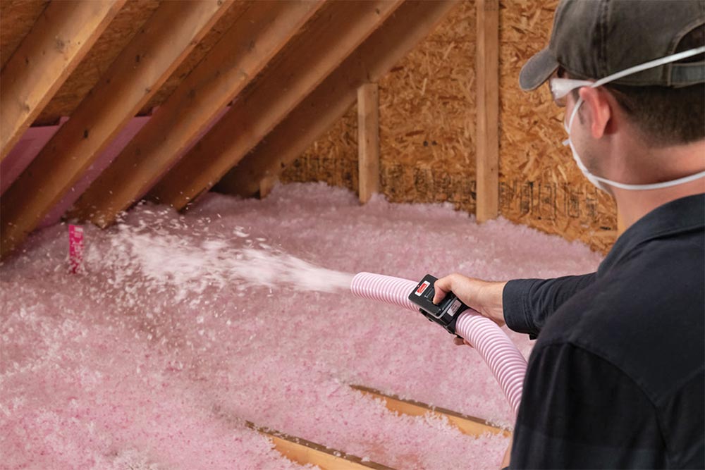 Person installing insulation in an attic