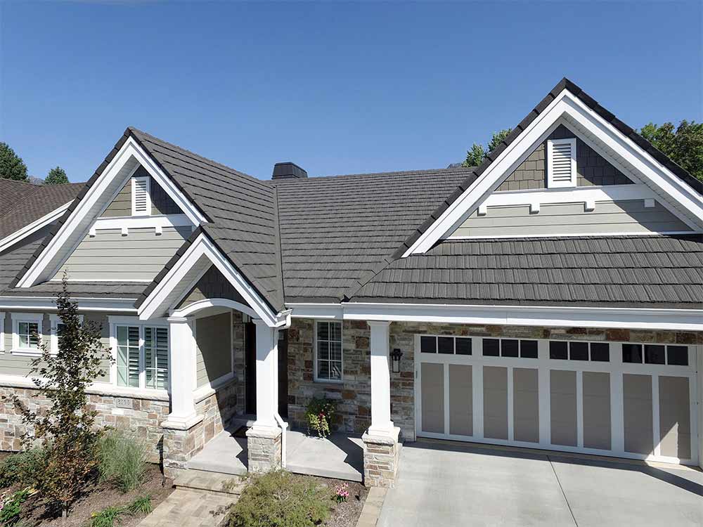 Two-story house with gray roof and white trim on a clear day
