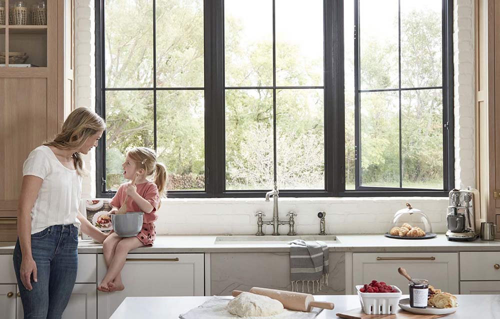 Woman and child in a kitchen with large windows