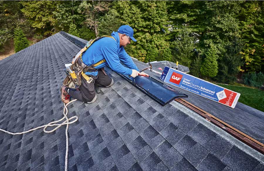 Person working on a roof with a GAF shingles