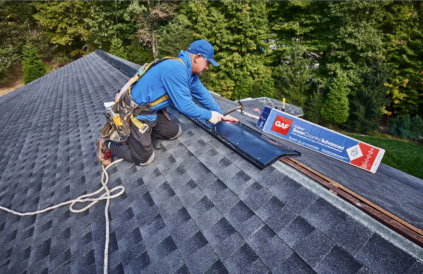 Person working on a roof with a GAF product visible